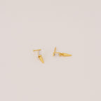 The Wren Spike Studs are lightweight, small spike-shaped earrings featuring CZ baguette diamonds and a pointed spike detail, set against a plain background.