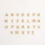 A set of letters on a white background, inspired by the Pave Initial Huggies—ideal for gifting someone a personalized touch.