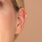 Close-up of dainty butterfly huggie hoop highlighting fitted clasp around ear.