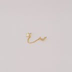 The Luna Moon & Star Chain Earrings feature gold star and moon studs linked by a delicate chain, creating unique chain stud earrings. Pictured on a simple light background.