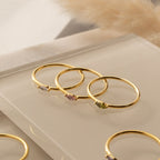 The Marquise Birthstone Ring features a gold band with a marquise-cut gemstone, perfect for stacking or wearing alone as a personalized accessory.