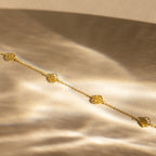 Elegant gold Flower Station Necklace with floral charms on a soft, golden satin background—perfect floral jewelry and a thoughtful gift for her.