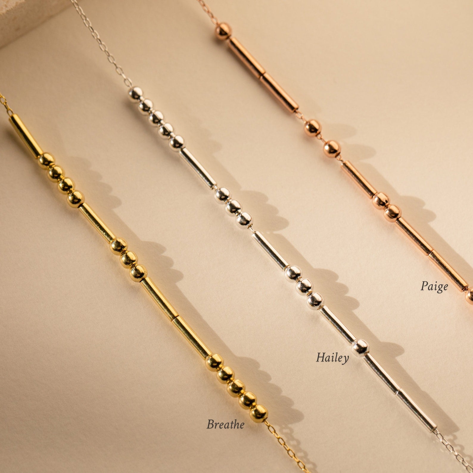 The Morse Code Necklace comes in gold, silver, and rose gold, with personalized messages like Breathe, Hailey, and Paige—a perfect gift to cherish daily.
