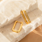 The Large Ribbed Link Hoops are showcased on textured stone surfaces in soft, natural lighting—ideal for fans of minimalist jewelry.