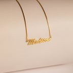 Natural Name Necklace in Box Chain featuring the name Madison in elegant cursive on a neutral beige background—a minimalist, custom gift perfect for any occasion.