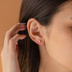 A close-up of a woman's ear wearing Booker Large Birthstone Studs—an elegant and thoughtful jewelry gift.