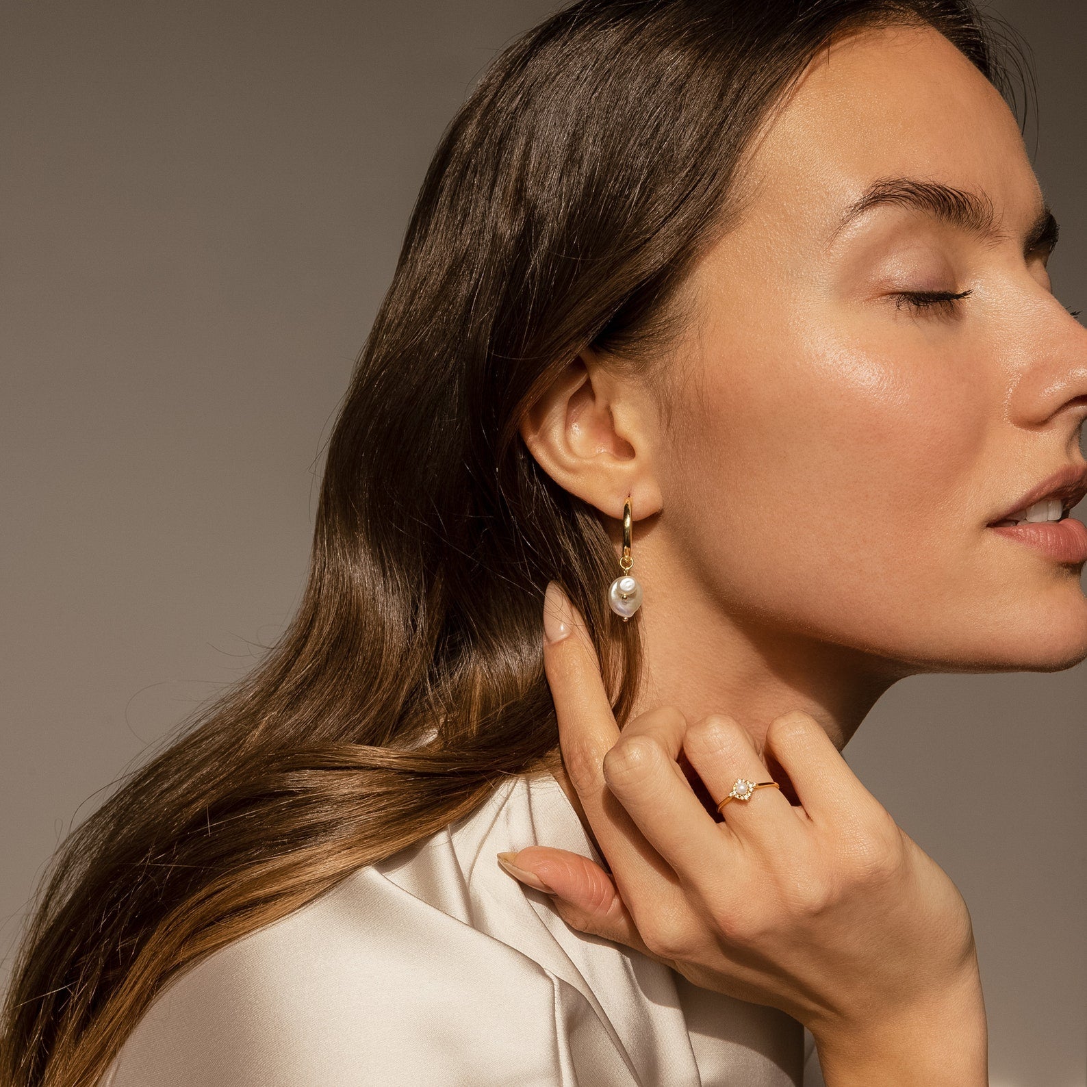 Woman with long brown hair wears the Vintage Pave Pearl Ring in 18K Gold, eyes closed and hand by her face—an elegant style that makes this ring a perfect Christmas gift.