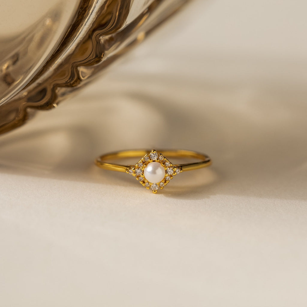 The Vintage Pave Pearl Ring in 18K Gold showcases a central pearl with pavé diamonds in a square setting on a reflective gold band—an elegant and exquisite Christmas gift choice.