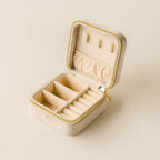 The Square Velvet Jewelry Case, in beige velvet with compartments and a zipper, is shown open against a neutral background.