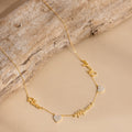 Grace Name Heart Necklace features a gold chain with personalized cursive name and Mom charms, plus two small heart pendants—an elegant custom necklace for any occasion.