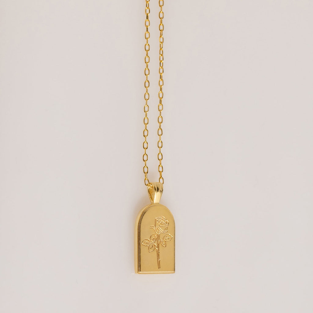 The Birth Flower Arch Necklace features a rectangular pendant with a rose engraving, displayed on a simple background—a beautiful personalized jewelry piece to enhance any outfit.