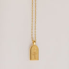 The Birth Flower Arch Necklace features a rectangular pendant with a rose engraving, displayed on a simple background—a beautiful personalized jewelry piece to enhance any outfit.