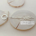 The Custom Handwriting Keychain features "I love you little one Mother" in script, replicating the handwritten note beside it—a perfect way to turn your handwriting into unique jewelry.