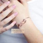 Close-up of a hand wearing the Handwriting Bracelet in rose gold, engraved with "Love You More" and heart shapes—an ideal personalized piece for everyday wear.