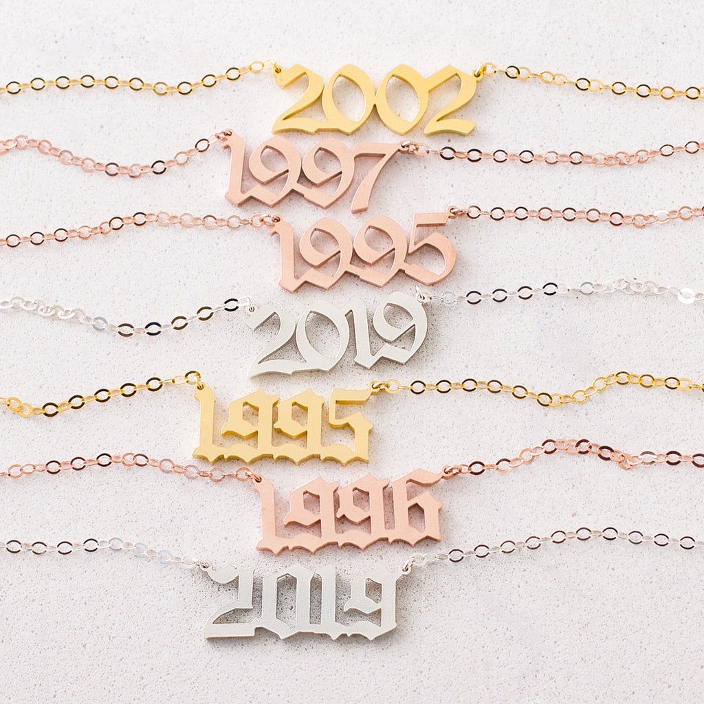 The Year Necklace features chains and pendants displaying 2002, 1997, 1995, 2019, and 1996—perfect as a birth year necklace or to add a unique gothic accessory to any outfit.