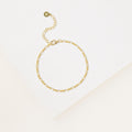 The Essential Bracelet Chains feature a delicate gold chain with an adjustable clasp and polished finish, showcased on a white textured surface.