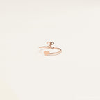The Initial Heart Wrap Ring showcases a rose gold heart on one end and a customizable lowercase initial "e" on the other—a delicate, personalized symbol of love set against a plain background.