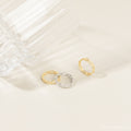 Pair of the gold and silver link rings placed closely together on a fabric backdrop, highlighting the linked design and contrast in finish.