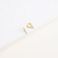 The Ezra Triangle Earrings—featuring one geometric triangle and one slim bar—are displayed on a white textured surface, highlighting their modern design and subtle pavé texture.