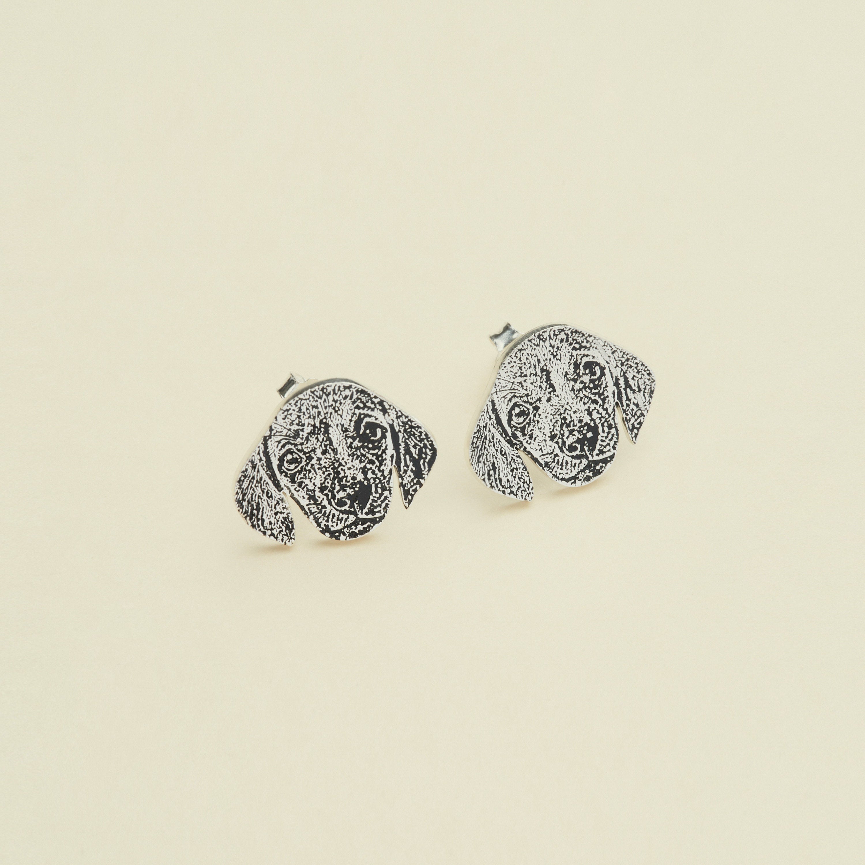 The Pet Portrait Studs are dog face-shaped earrings shown on a plain background—ideal custom pet jewelry for any animal lover and a charming addition to your collection.