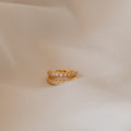 The Vera Pave Huggies are displayed on a soft beige fabric background, ideal for pairing with minimalist earrings or other everyday jewelry.