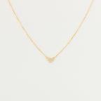 The Pave Heart Necklace features a gold chain with a minimalist heart pendant adorned with tiny clear stones—a delicate accessory perfect for everyday elegance.