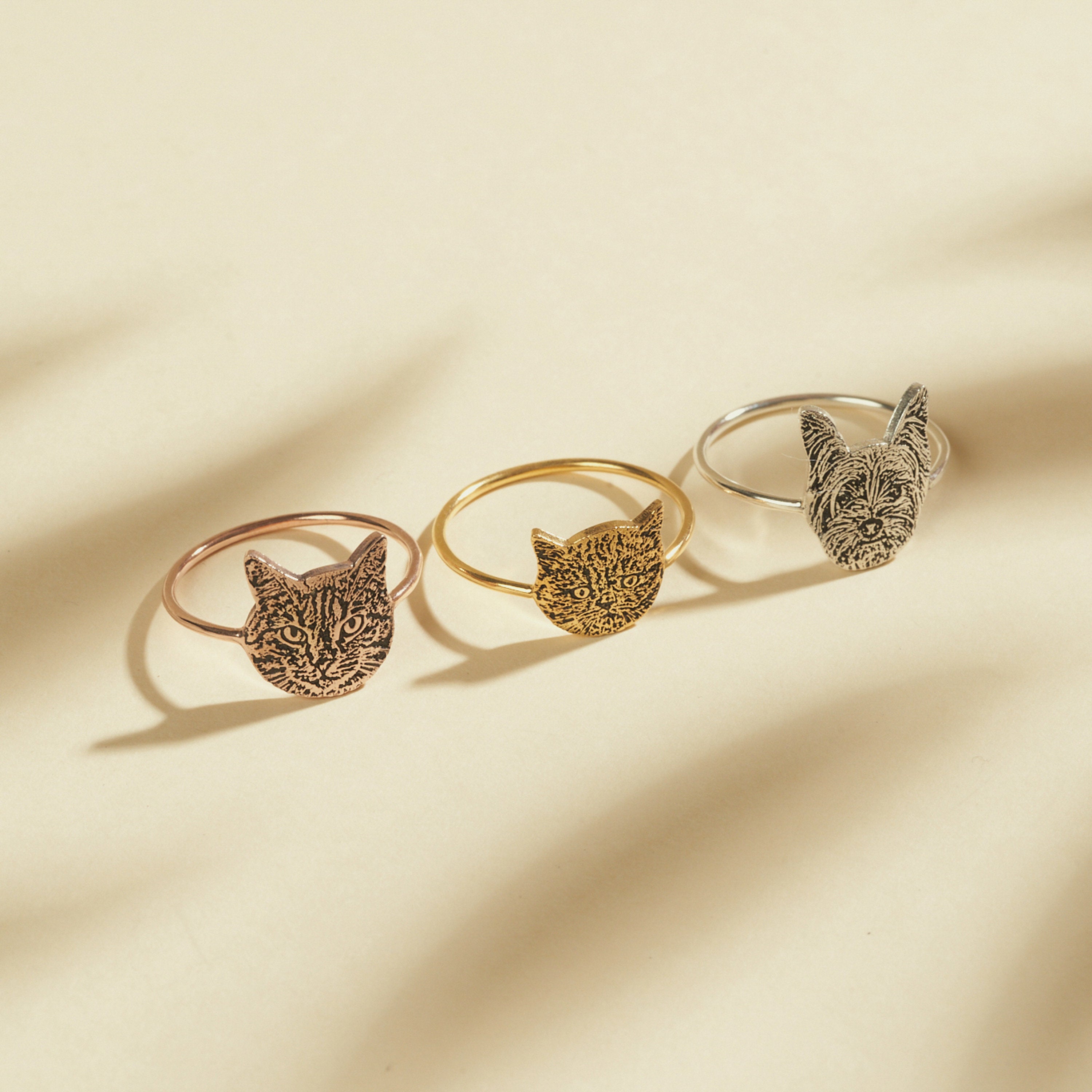 The Pet Portrait Ring features three cat-shaped designs in rose gold, gold, and silver on a neutral background—perfect custom jewelry for cat lovers seeking a unique pet-themed ring.