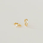 A pair of Athena Huggies crafted in gold and delicately accented with a sparkling diamond.