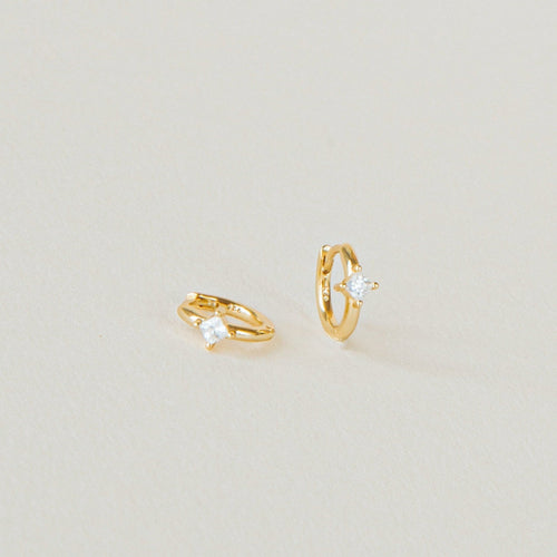 A pair of Athena Huggies crafted in gold and delicately accented with a sparkling diamond.