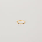 The Amber Eternity Ring is a delicate gold, stackable ring featuring small beads along its band, shown on a plain white background.
