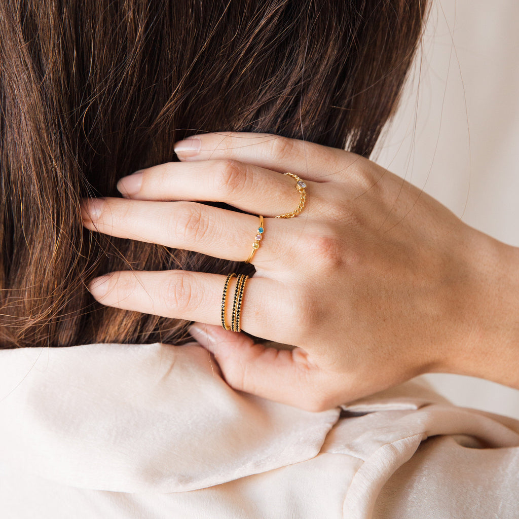 A close-up of a hand adorned with rings, featuring the Amber Eternity Ring.