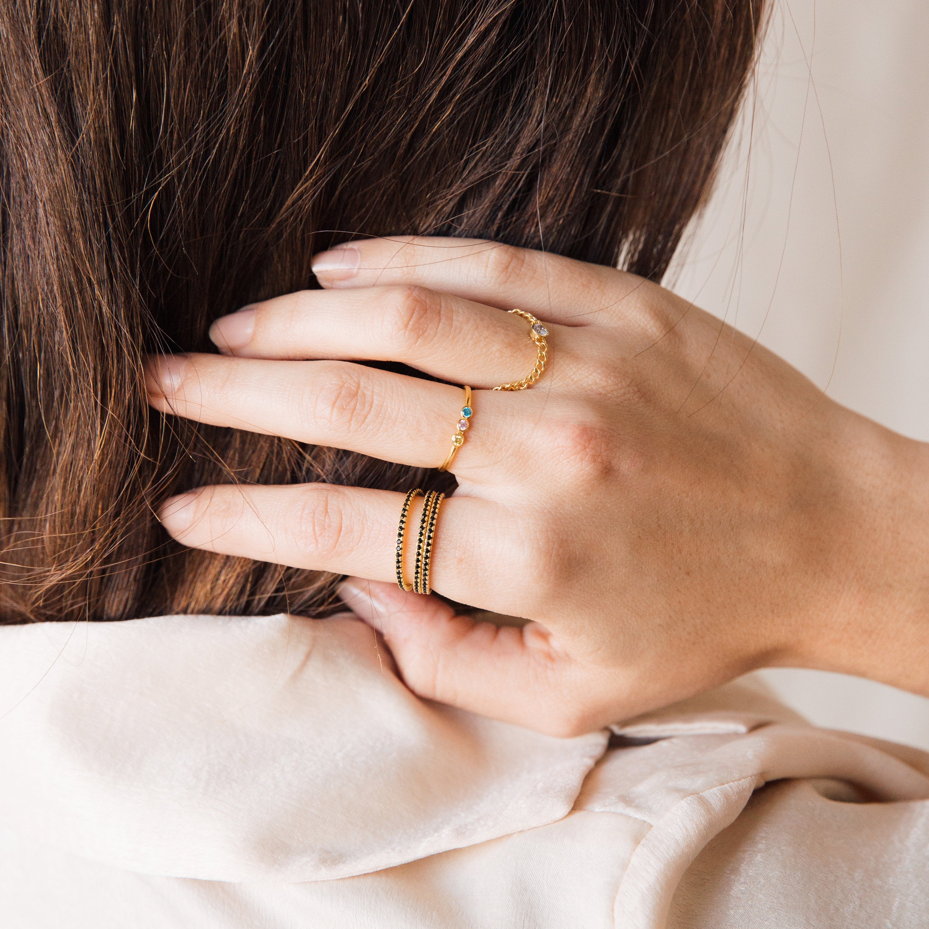 A close-up of a hand adorned with rings, featuring the Amber Eternity Ring.