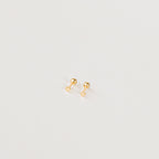 The Tiny Heart Studs in 18K Gold are a perfect gift, featuring delicate heart-shaped gold studs on a white surface—ideal for everyday wear.